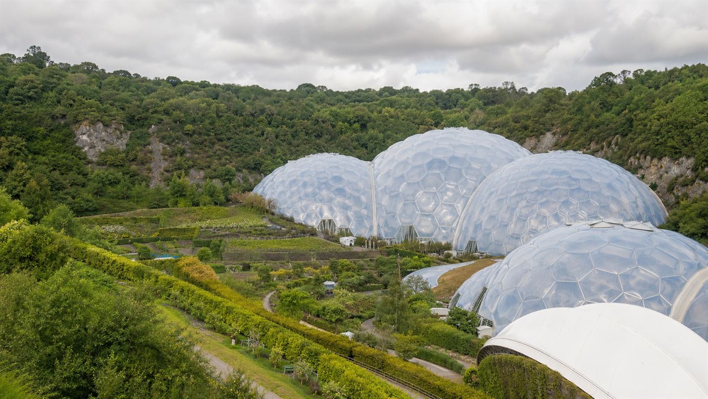 The Eden Project's huge white geodesic bubble domes nestled in a green reclaimed clay crater in Cornwall