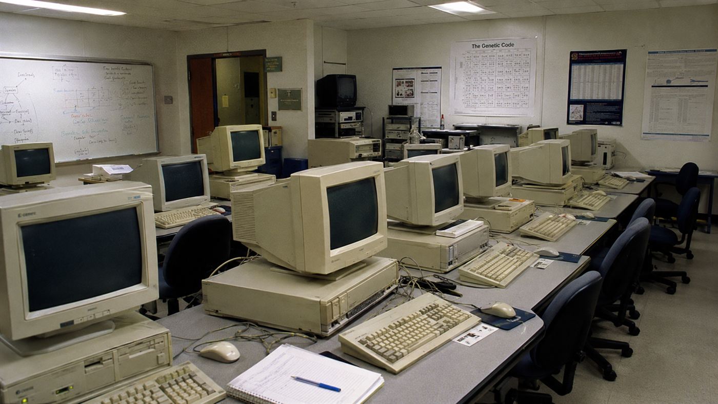 An early 1990s university computer lab with beige workstations and bulky monitors