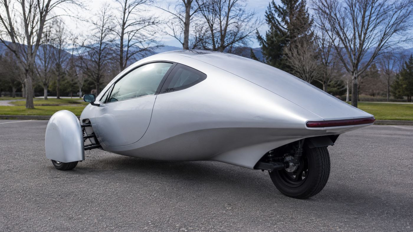 Rear view of the Aptera three-wheeler showing its single rear wheel and aerodynamic teardrop tail