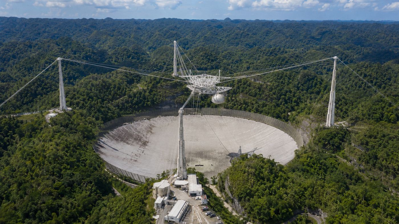 The Arecibo Observatory, a 305-meter radio telescope dish set in a green sinkhole in Puerto Rico