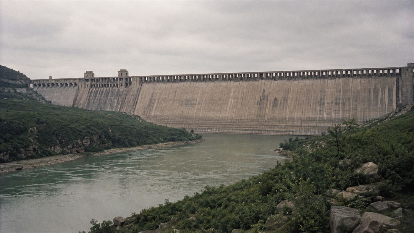 The Banqiao Dam on the Ru River in Henan Province China, a concrete dam wall above a wide river valley, grey sky, historical engineering photograph