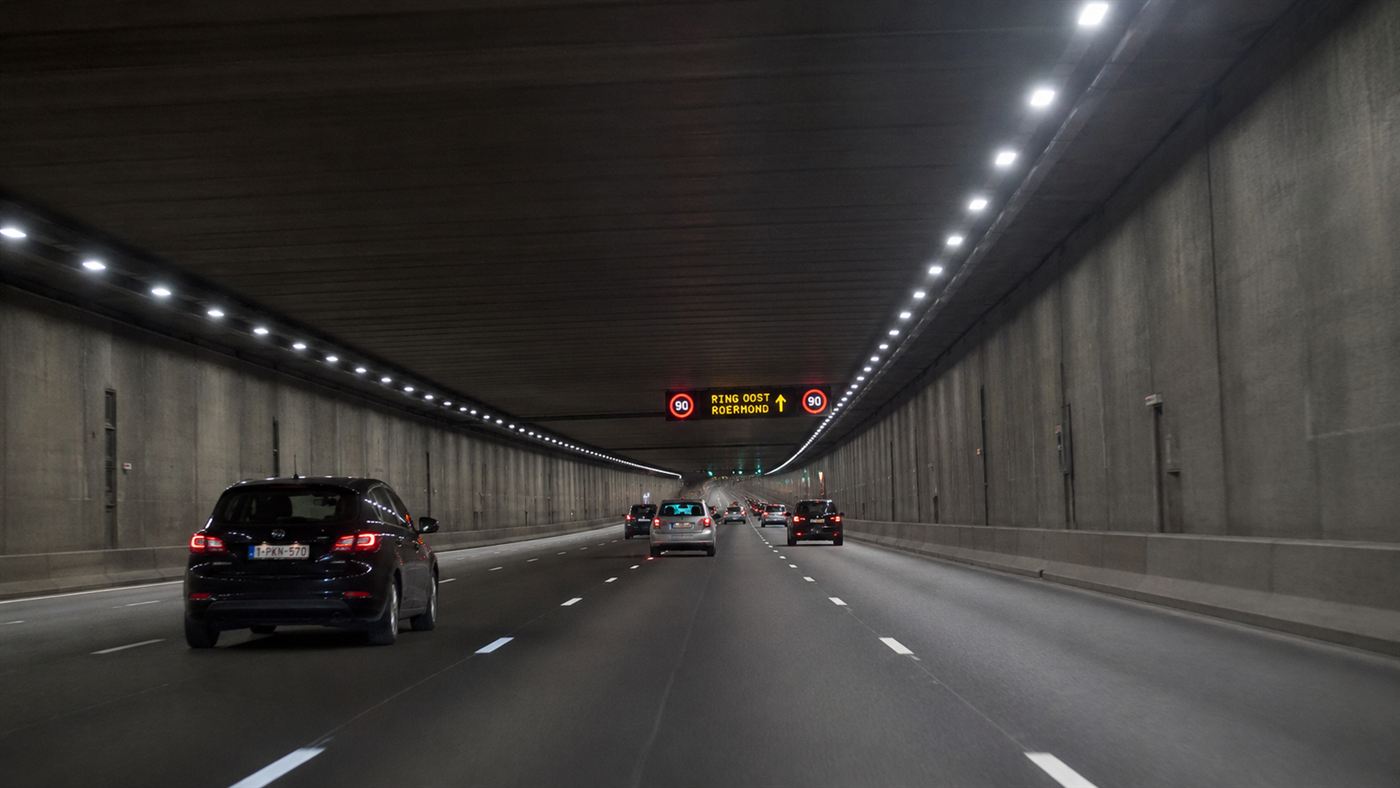 A wide modern multi-lane underground highway tunnel with cars, like the Big Dig in Boston