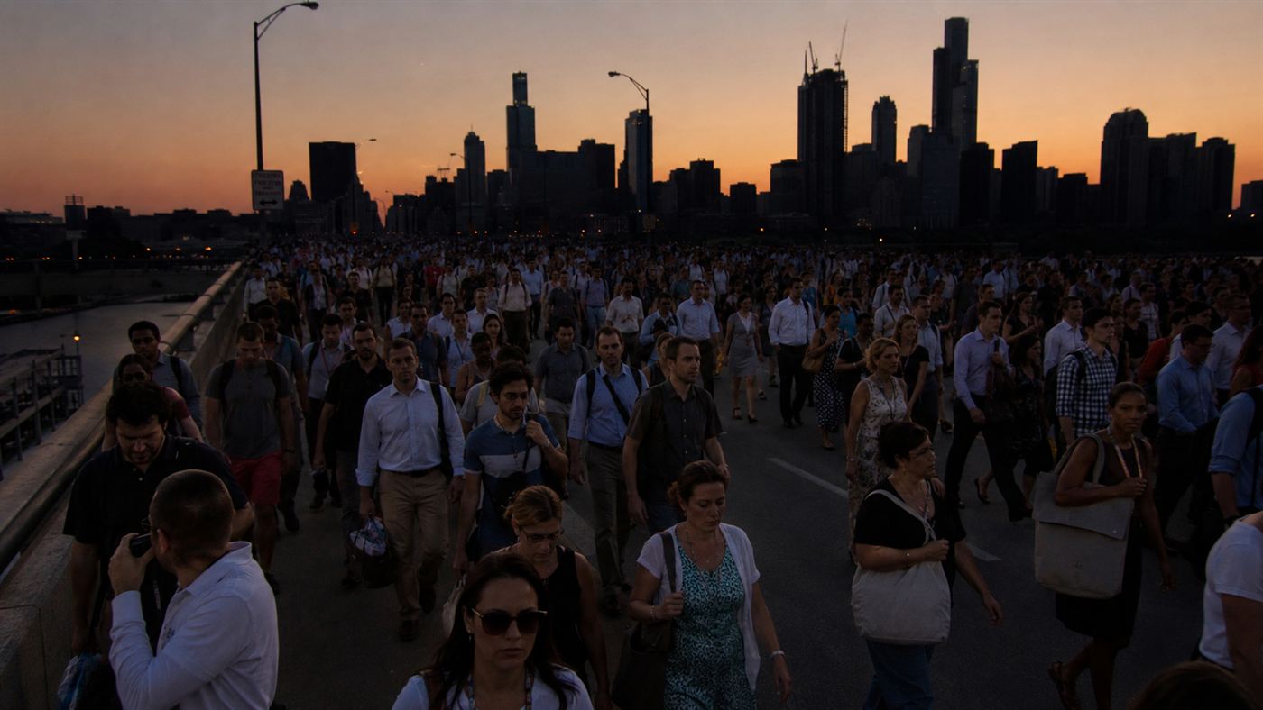 Huge crowds of commuters walking home across a city bridge at dusk during the 2003 blackout