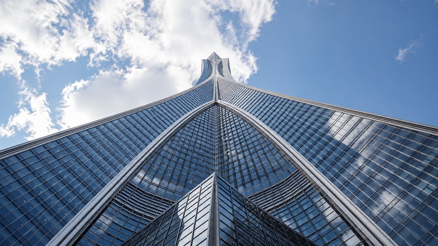 A low-angle view up the soaring three-winged Y-shaped facade of a supertall skyscraper