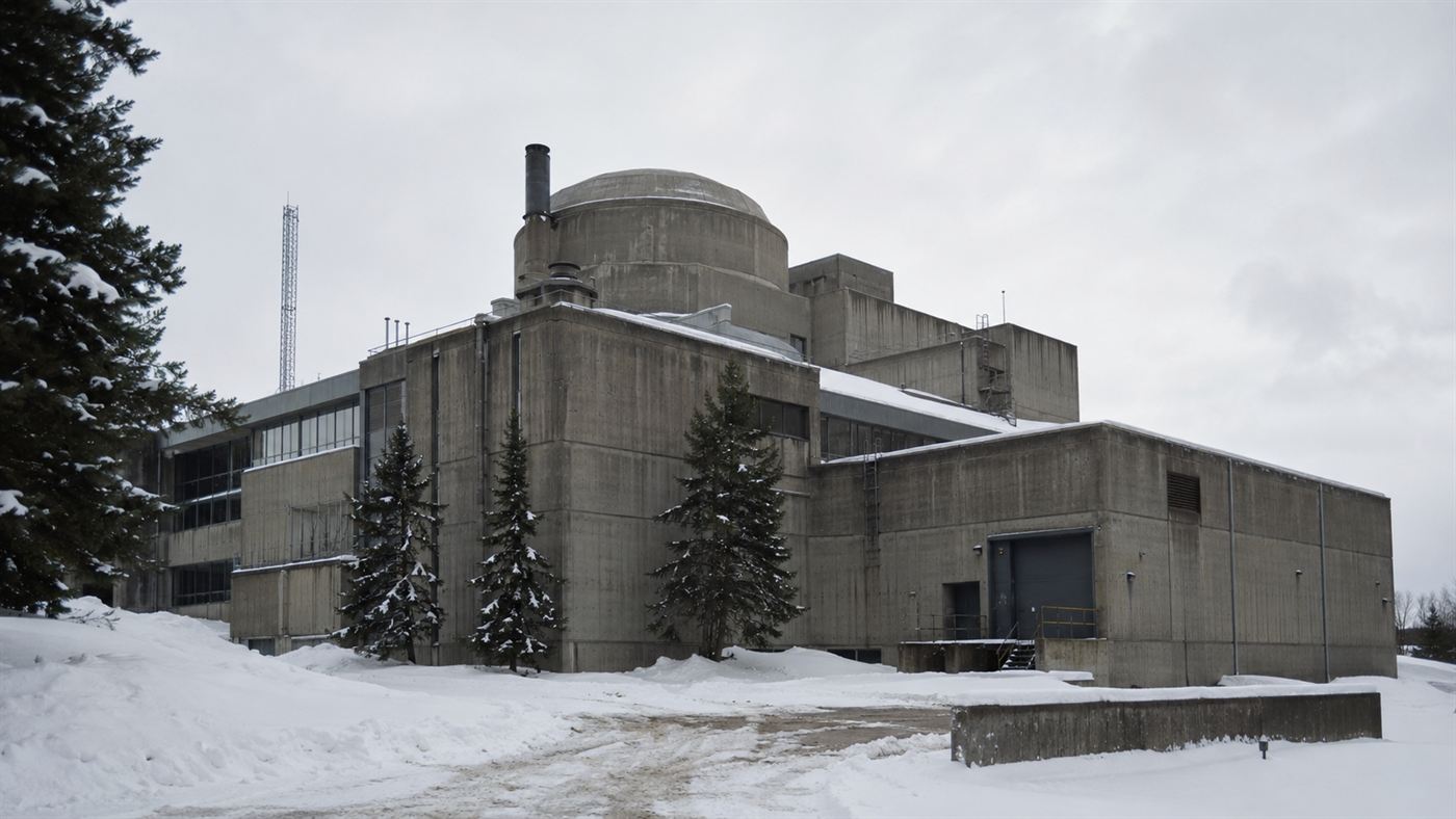 Chalk River nuclear reactor facility Ontario Canada 1950s, NRX reactor building exterior with industrial infrastructure surrounded by pine trees and snow