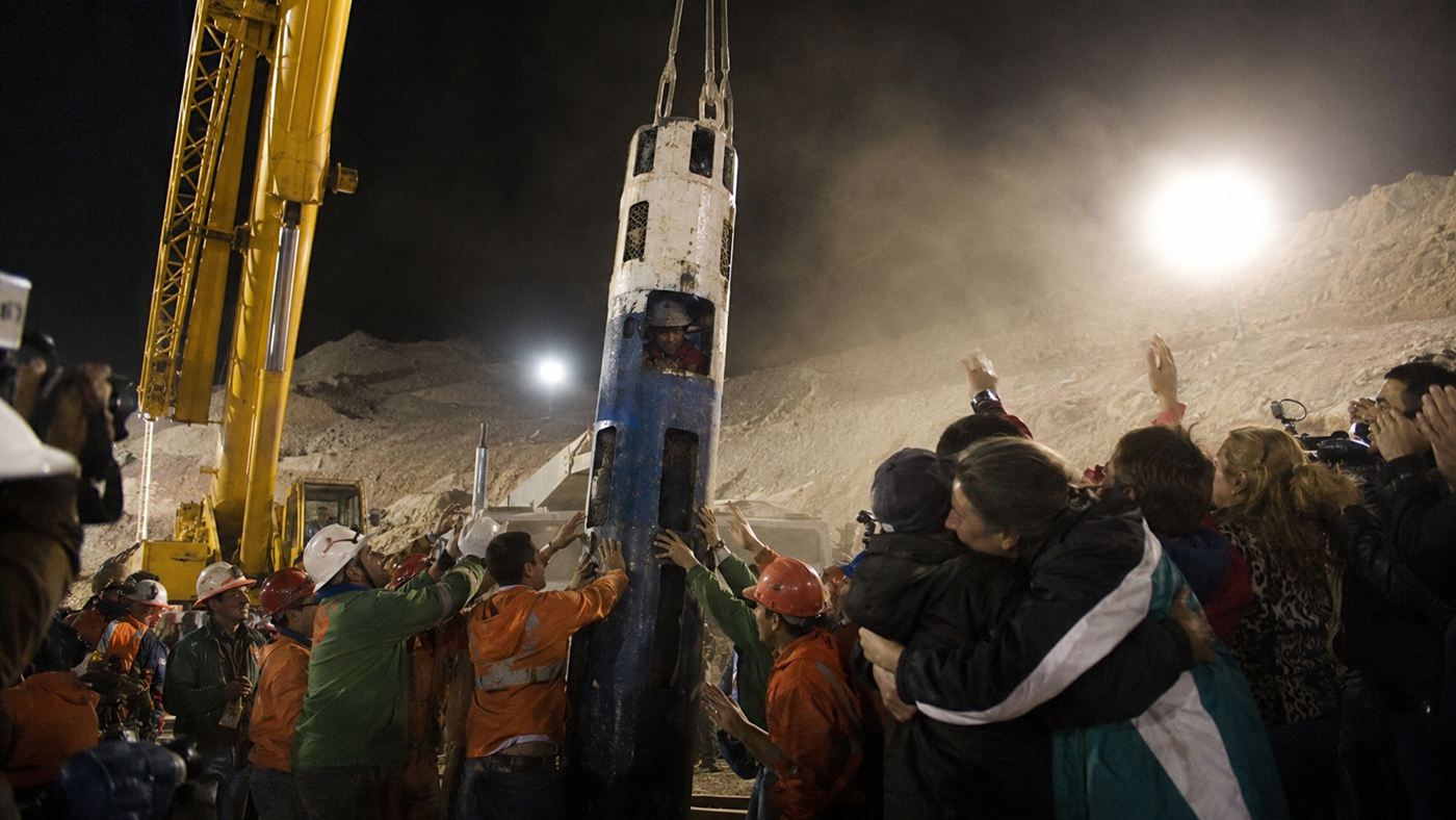 The narrow Fenix rescue capsule emerging at a floodlit Chilean mine head as the Chilean miners are brought up