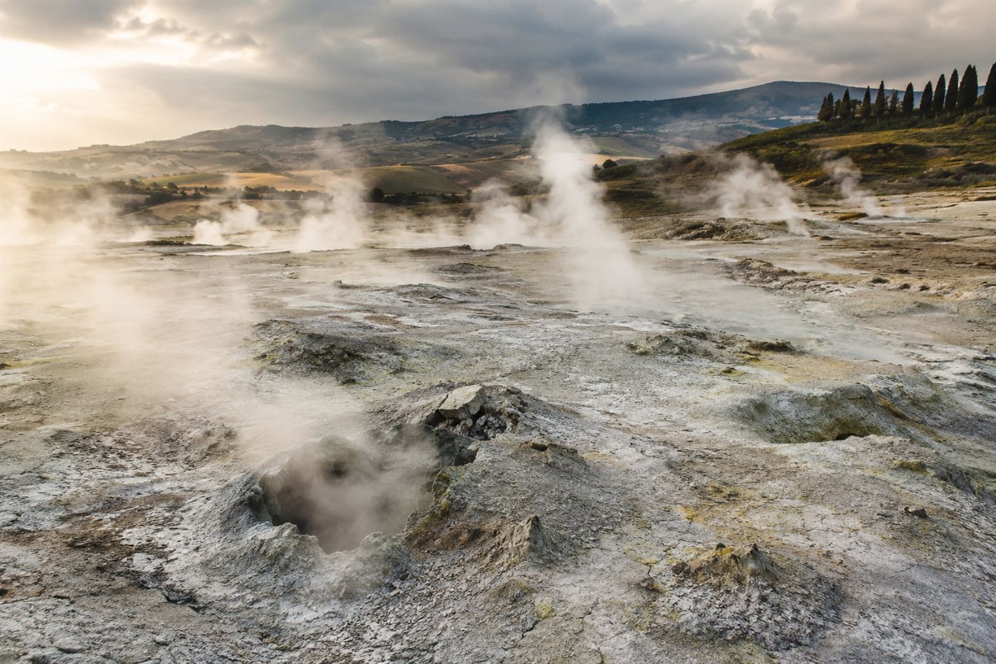 Steam vents and fumaroles hissing from pale sulfurous ground in the Devil's Valley near Larderello