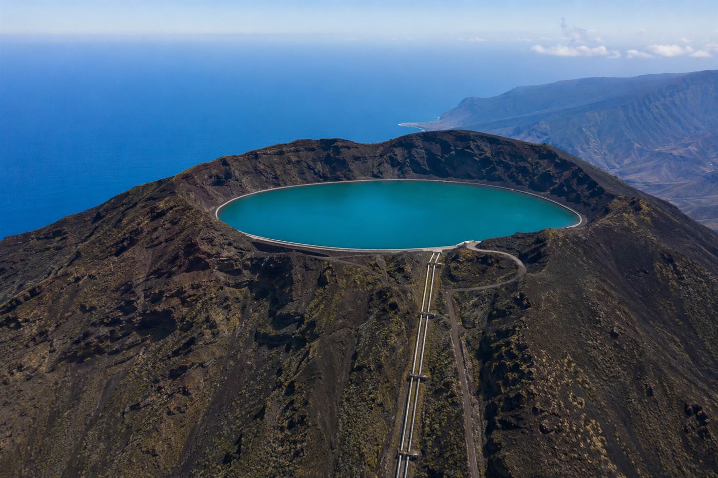 An upper water reservoir held inside the crater of an extinct volcano on El Hierro, high above the sea