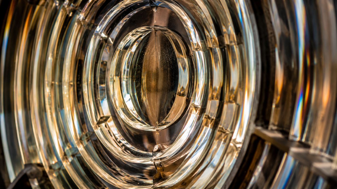 Extreme close-up of the concentric glass prism rings of an antique Fresnel lens bending light
