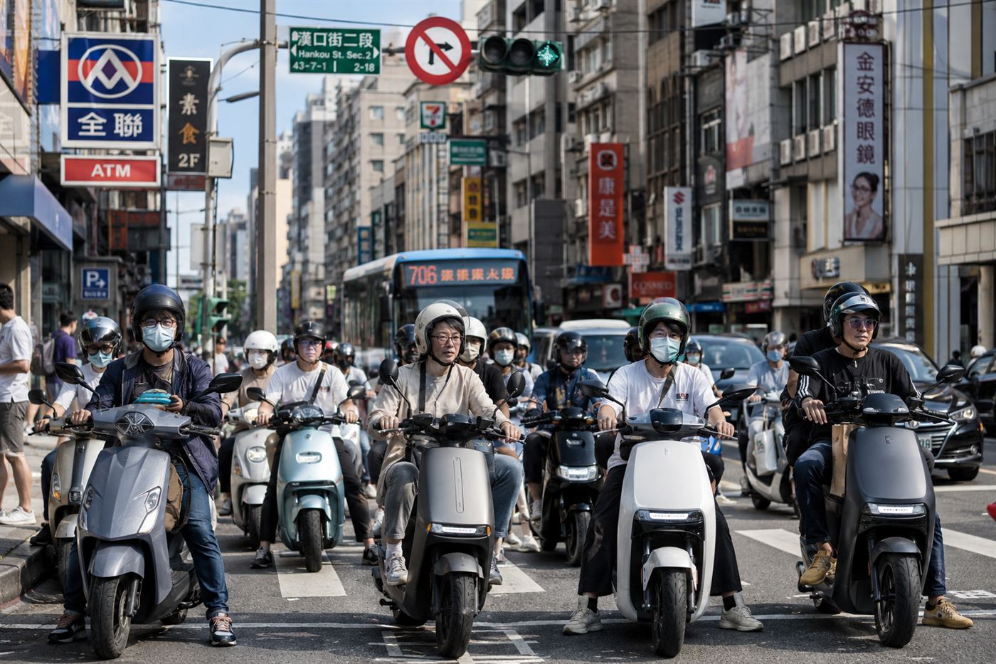 A busy Taiwanese city street crowded with modern electric scooters waiting at a traffic light