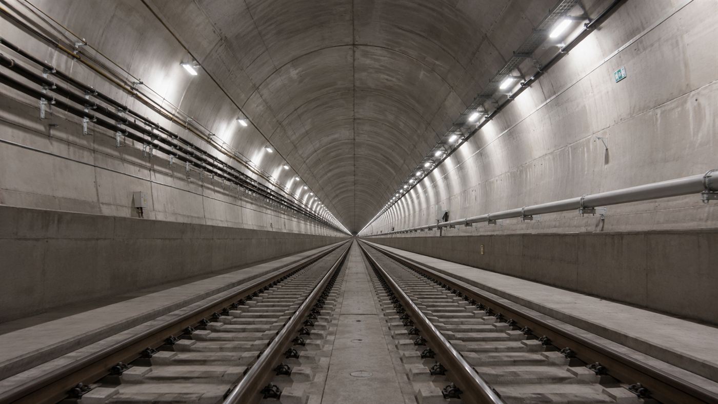 The long lit interior of the Gotthard Base Tunnel with twin tracks running dead straight into the distance