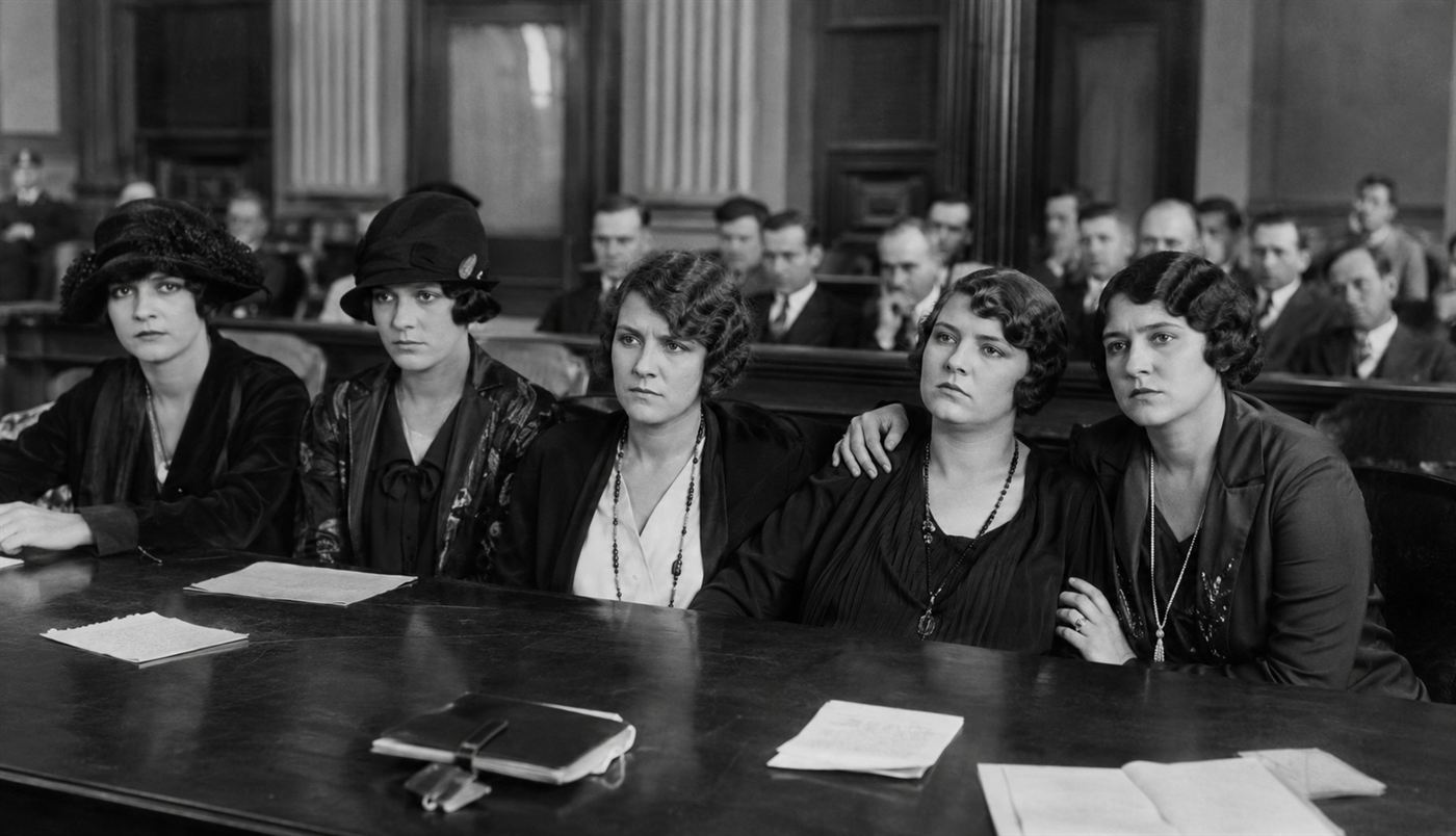 Grace Fryer and four Radium Girls plaintiffs in formal 1920s dress seated at a courtroom table, serious expressions, New Jersey 1928 legal proceedings, photorealistic historical scene