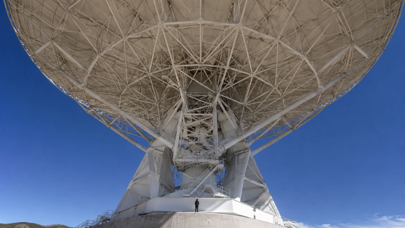 Looking up at the huge white dish of the radio telescope at Green Bank against a blue sky