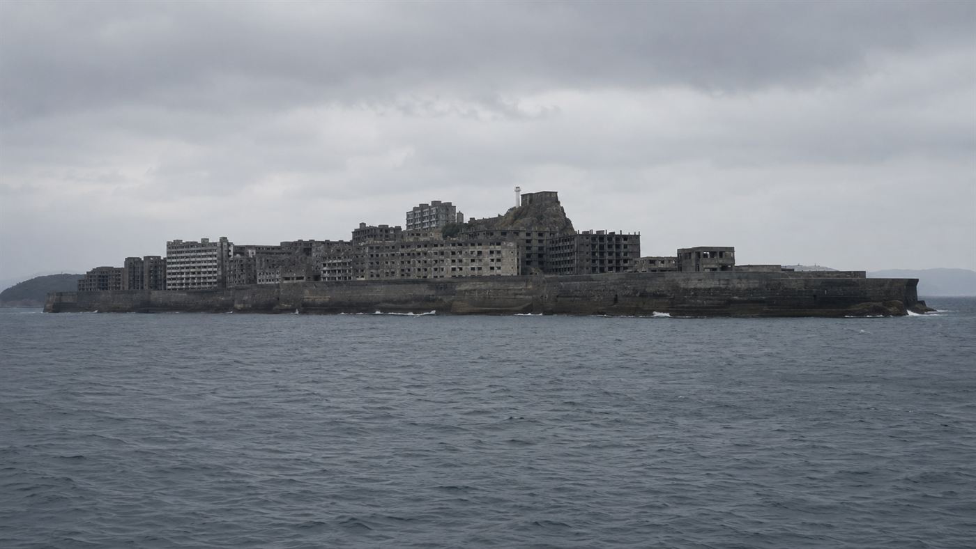 The abandoned Hashima Island, or Gunkanjima, a concrete ghost city rising from the gray sea off Nagasaki, Japan, ringed by a seawall