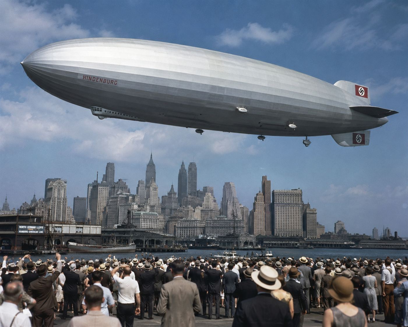 The massive Hindenburg zeppelin airship in flight over New Jersey, enormous hydrogen-filled airship against a blue sky, crowds watching from below at Lakehurst
