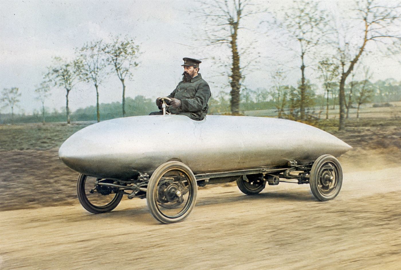 The torpedo-shaped silver electric car La Jamais Contente racing in 1899 with driver Camille Jenatzy