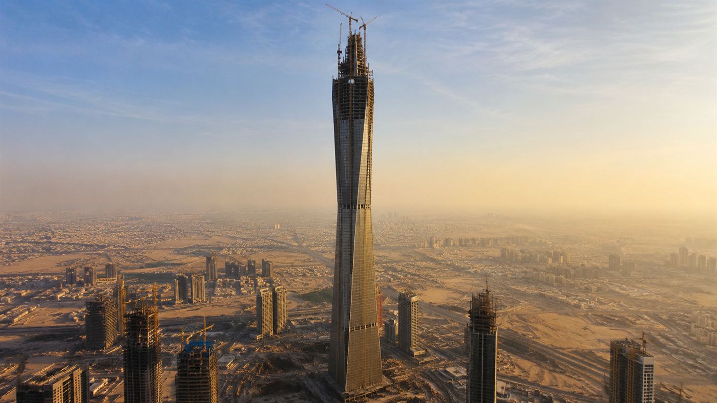 The tapering Jeddah Tower under construction rising far above a hazy desert city