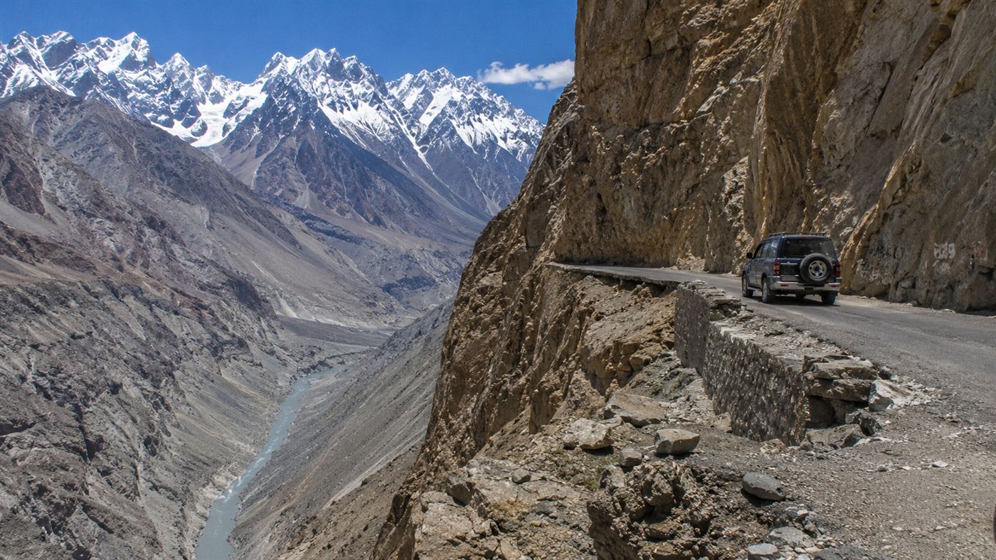 The Karakoram Highway clinging to a cliff high in the snow-capped mountains