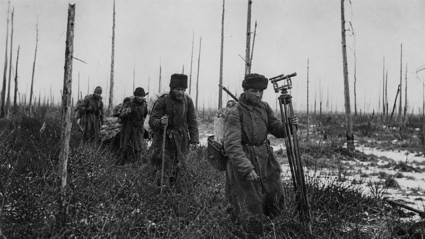 A 1920s expedition team trekking through Siberian taiga among bare standing dead trees at Tunguska