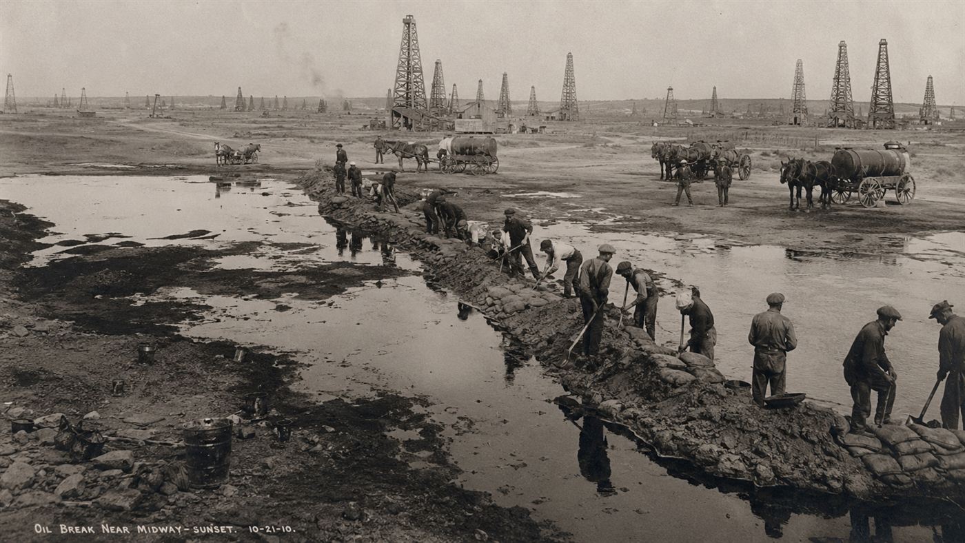 Workers building sandbag dikes to dam lakes of spilled oil at the Lakeview Gusher in 1910