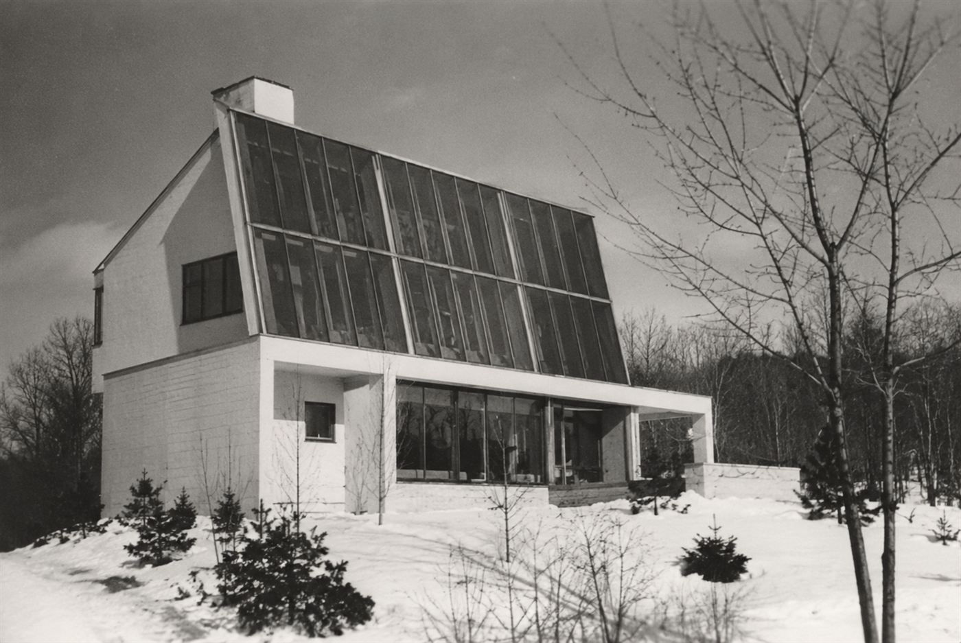 The Dover Sun House of 1948, a modernist home with a tall wall of solar collector glass in the snow