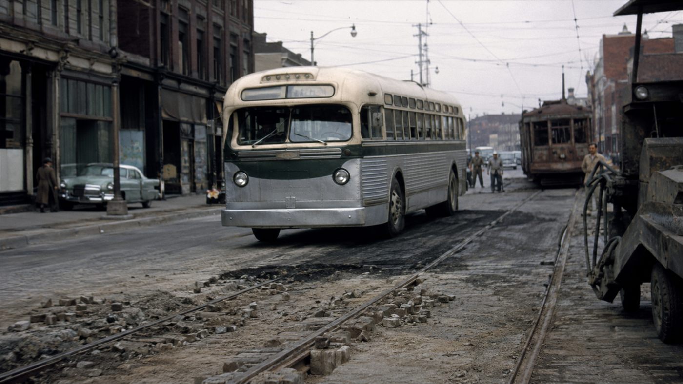 A National City Lines diesel bus replacing an electric streetcar route on a city street