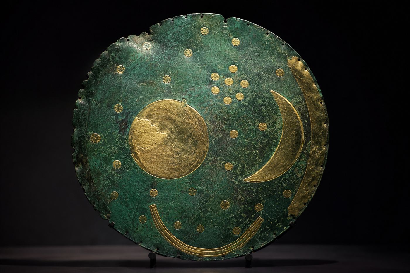 The Nebra sky disc, a round blue-green bronze disc inlaid with gold symbols of a sun, crescent moon and scattered stars