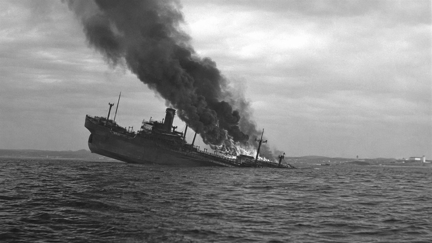 An oil tanker burning and listing on the Atlantic off the US coast after a U-boat attack in 1942
