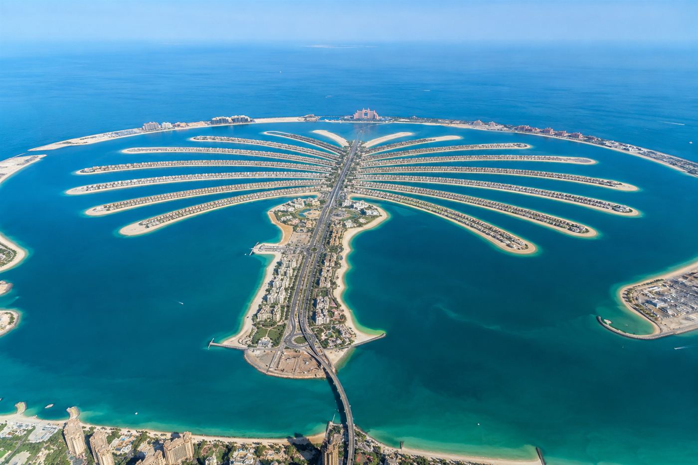 An aerial view of Palm Jumeirah, the palm-tree-shaped artificial island off Dubai, with its trunk, fronds and crescent breakwater in turquoise sea