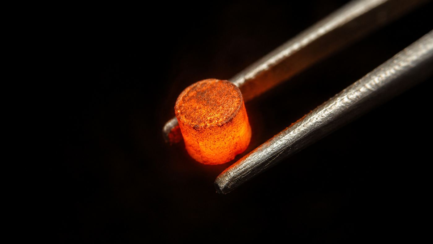 A pellet of plutonium-238 glowing from its own decay heat, the power source of the nuclear pacemaker