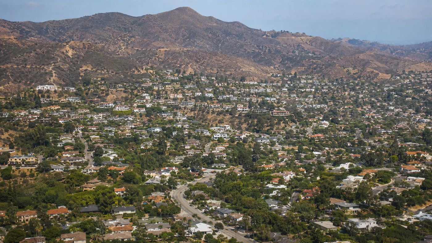 A suburban neighborhood of houses on hillsides below the Santa Susana Mountains near Los Angeles