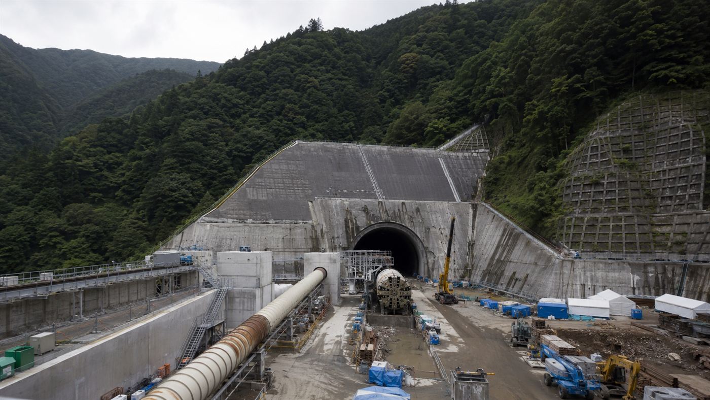 A large tunnel boring construction site under steep forested Japanese mountains for the SCMaglev line