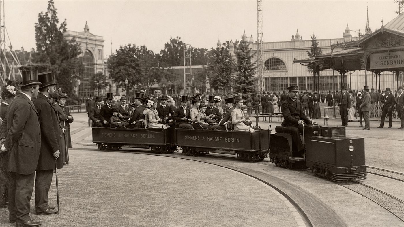 The first electric railway at the 1879 Berlin exhibition, a small locomotive pulling open cars of passengers