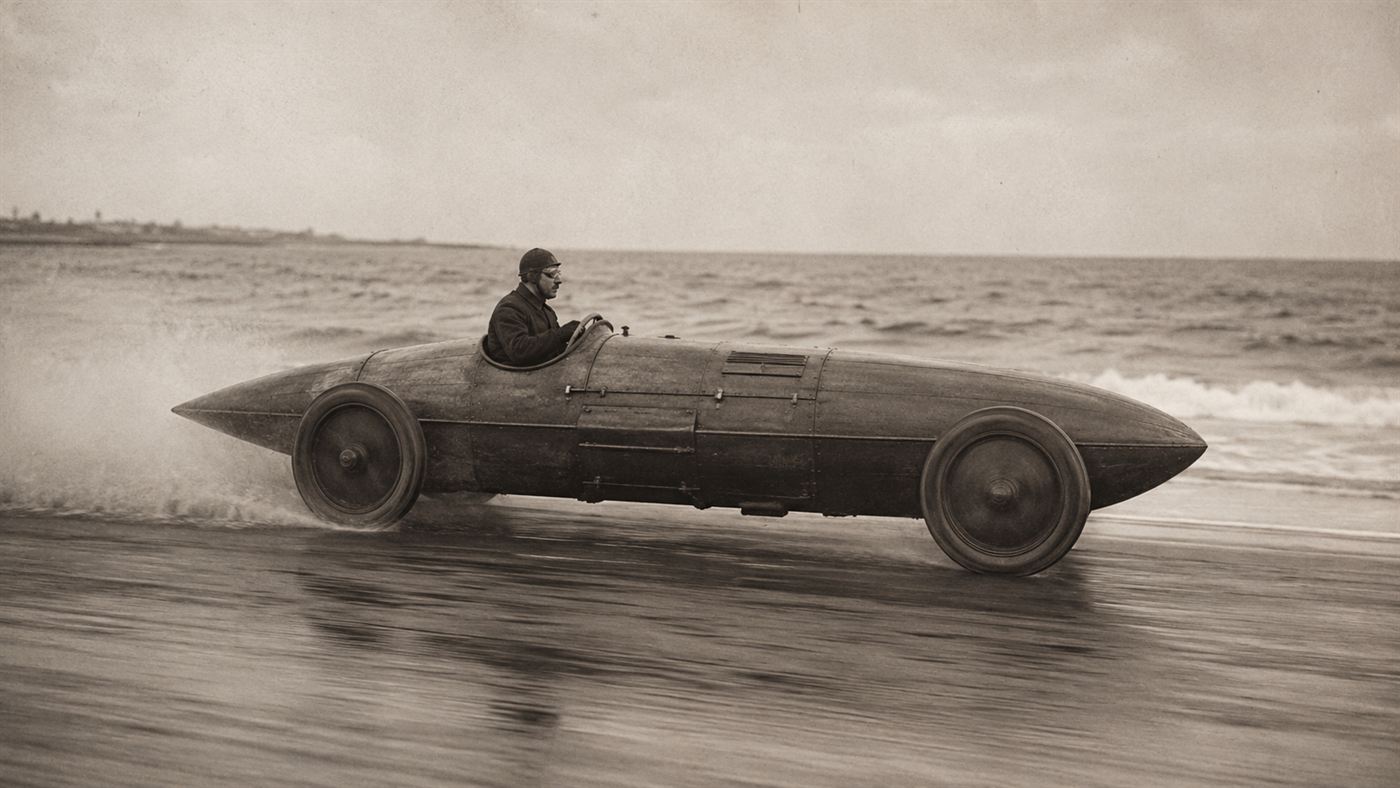 The streamlined boat-shaped Stanley Steamer racer speeding along a hard sand beach in 1906 throwing up a fine spray