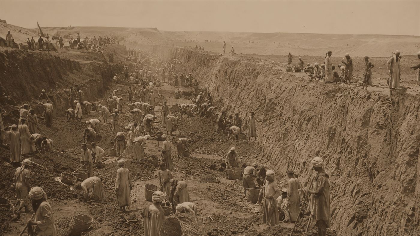 Crowds of 1860s Egyptian labourers digging the Suez Canal by hand with baskets in the open desert