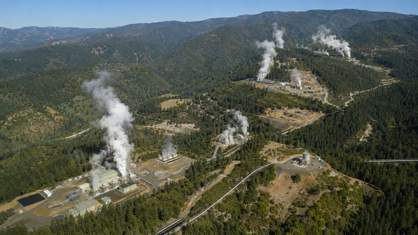 Steam rising from The Geysers geothermal field power plants in the forested Mayacamas Mountains of California
