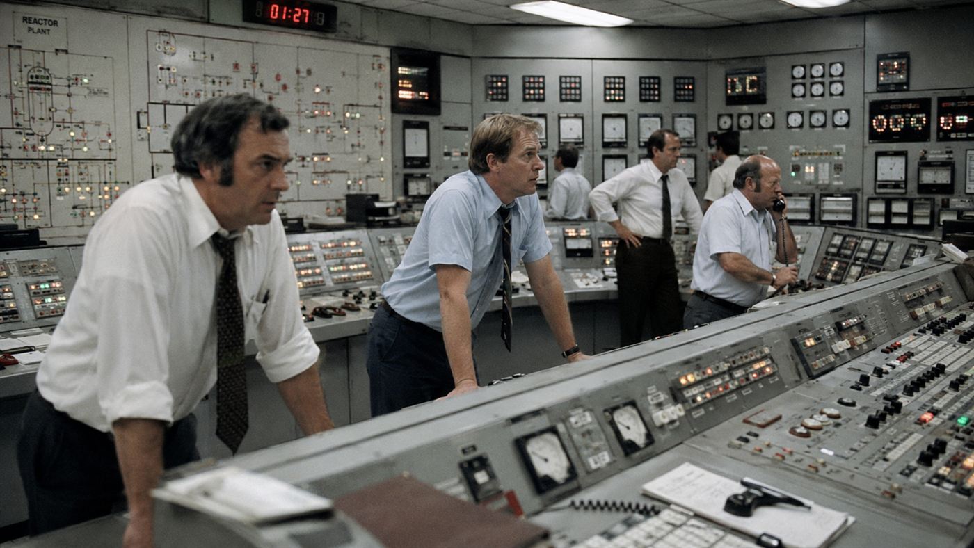 A tense 1970s nuclear control room with operators at analog panels, evoking the 1979 Three Mile Island accident