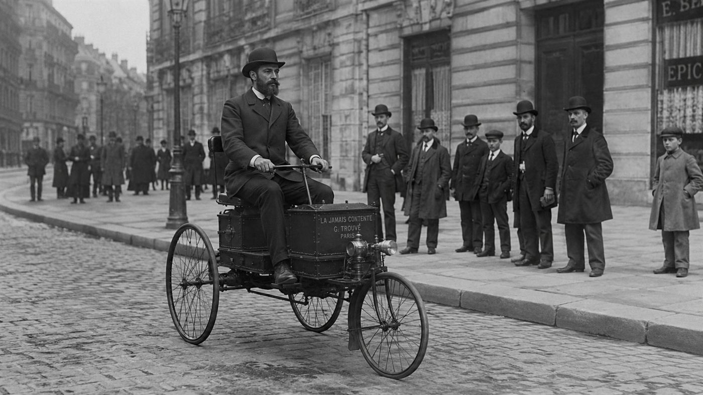 A man riding the first electric vehicle, a battery-powered tricycle, on a Paris street in 1881