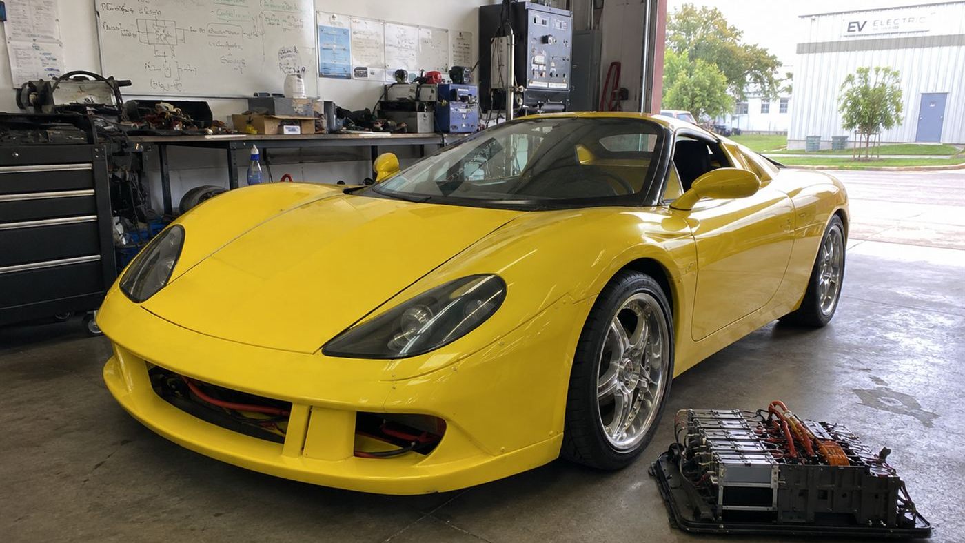 A low yellow hand-built electric sports car, the AC Propulsion tzero, in a California workshop