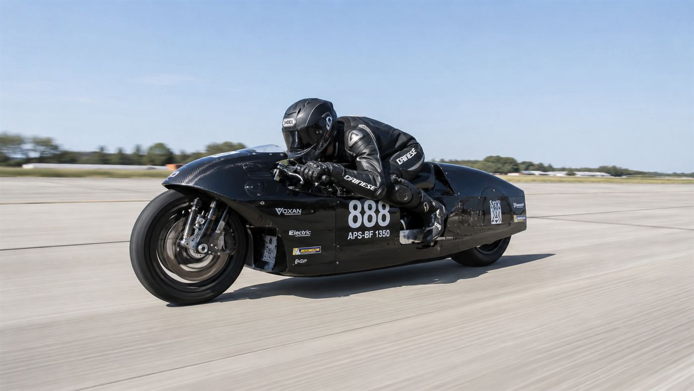The Voxan Wattman electric record motorcycle at high speed on a long runway, rider tucked low