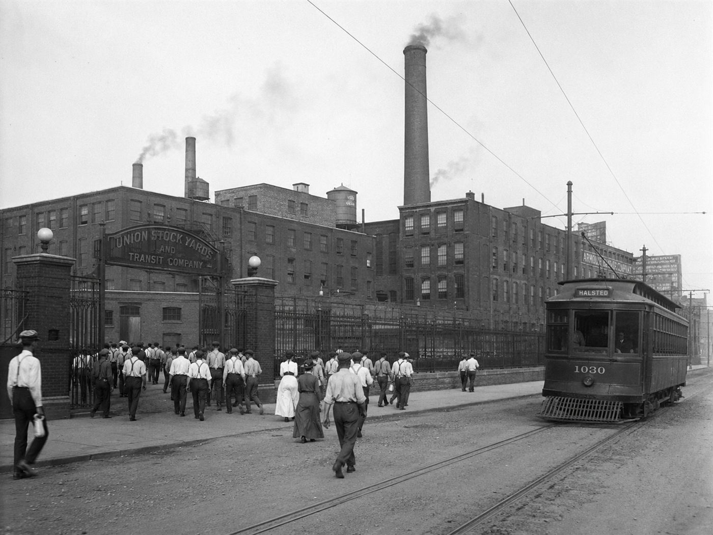 Western Electric Hawthorne Works factory complex in Cicero Illinois around 1910s, large brick industrial buildings with workers in period clothing outside