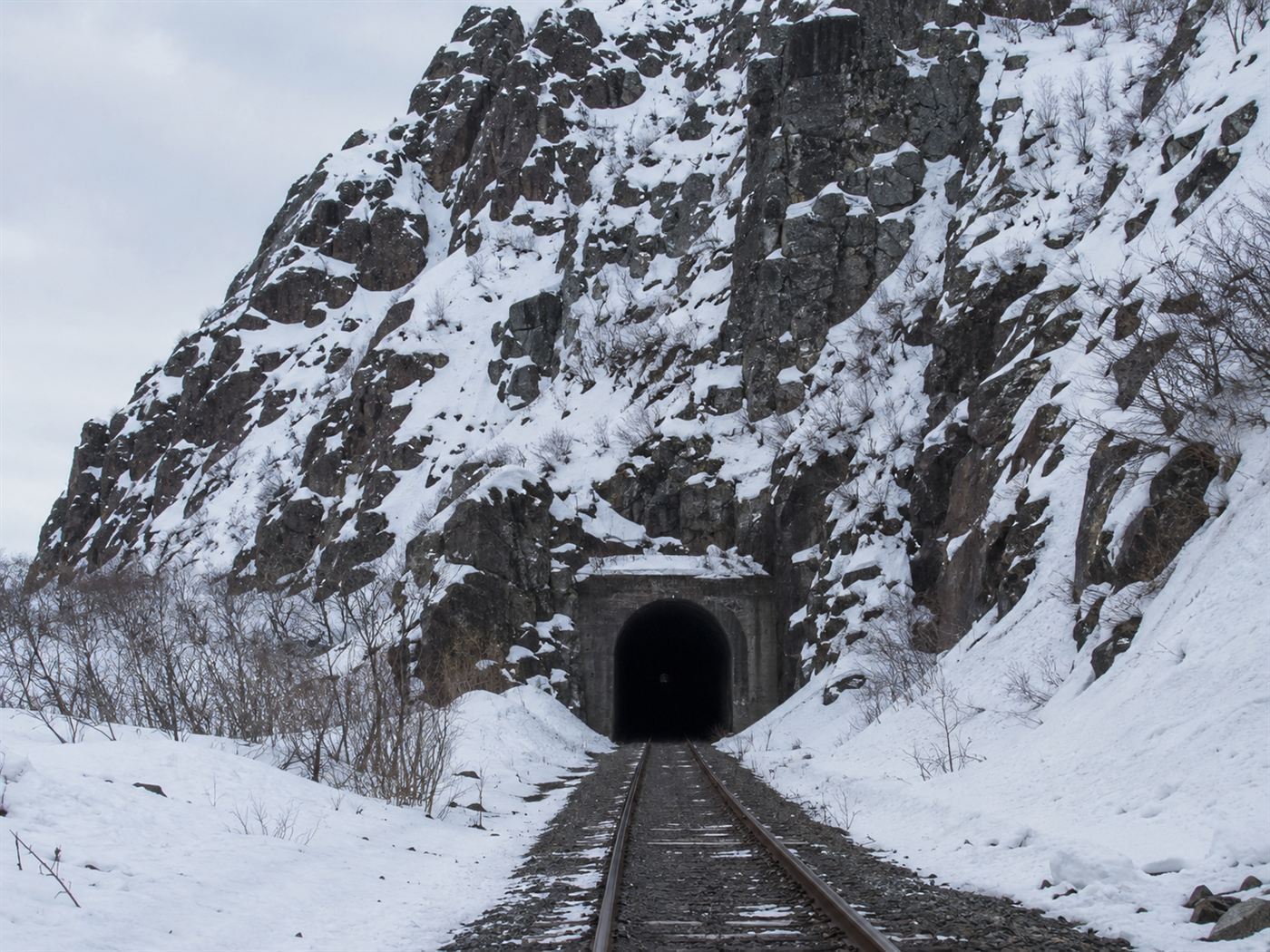 The one-lane Anton Anderson tunnel cut through a snowy mountain, the only road into Whittier, shared by cars and trains