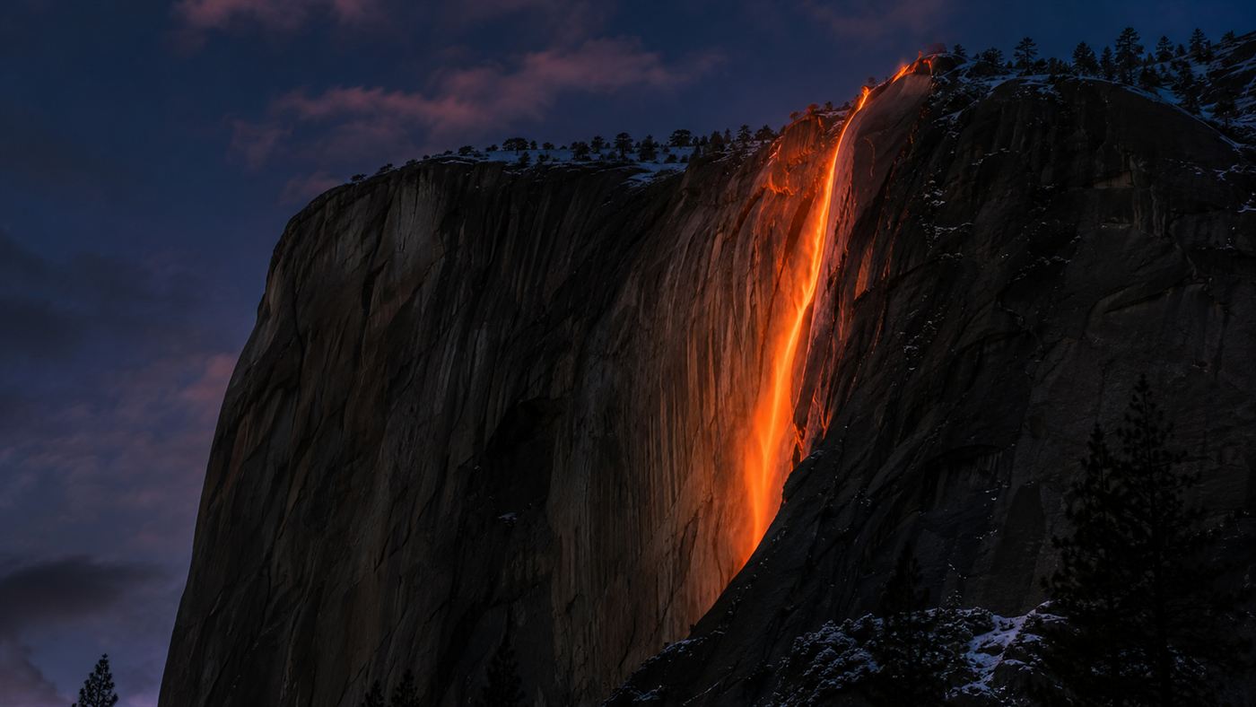 Horsetail Fall glowing bright orange like molten lava as the setting February sun lights it against the dark cliff of El Capitan in Yosemite