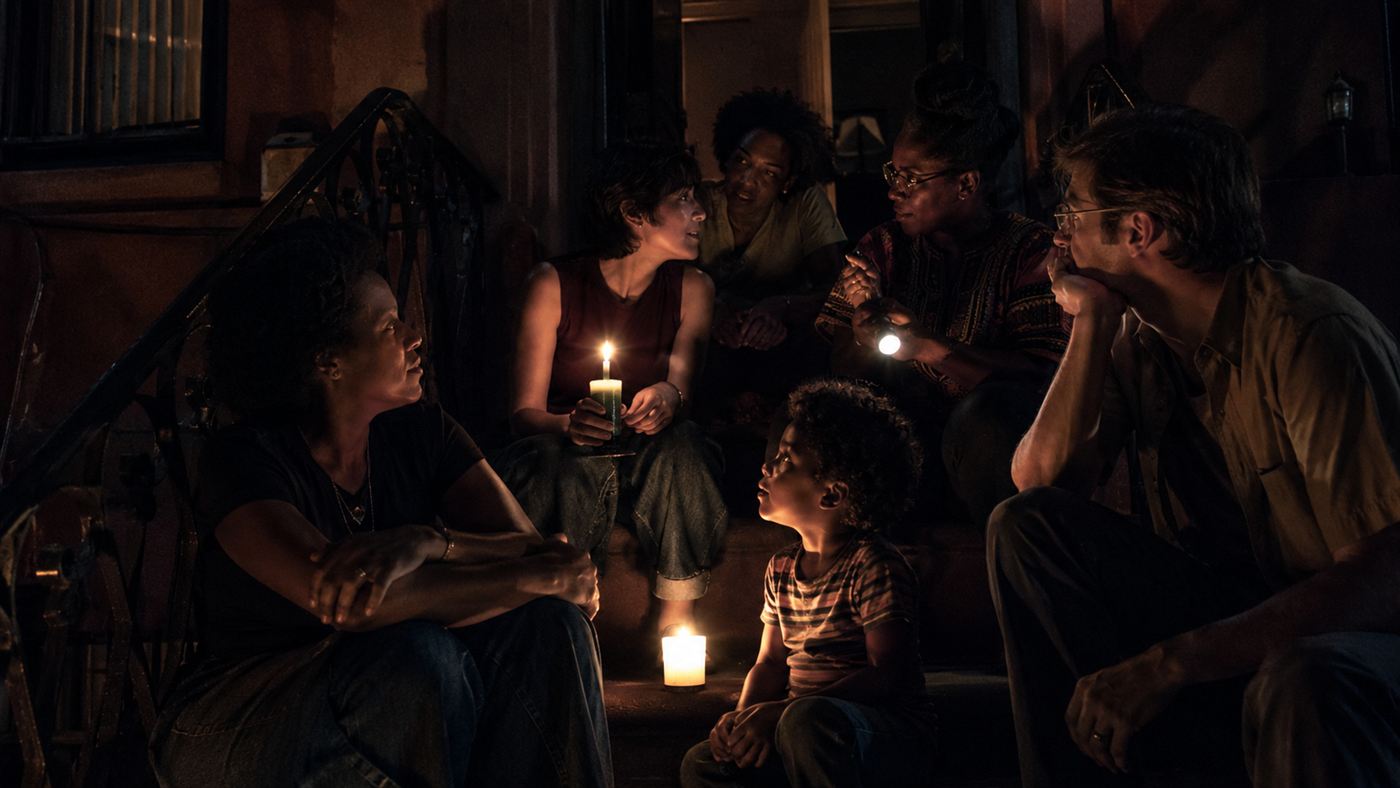Neighbours gathered by candlelight on a stoop during the 1977 New York City blackout