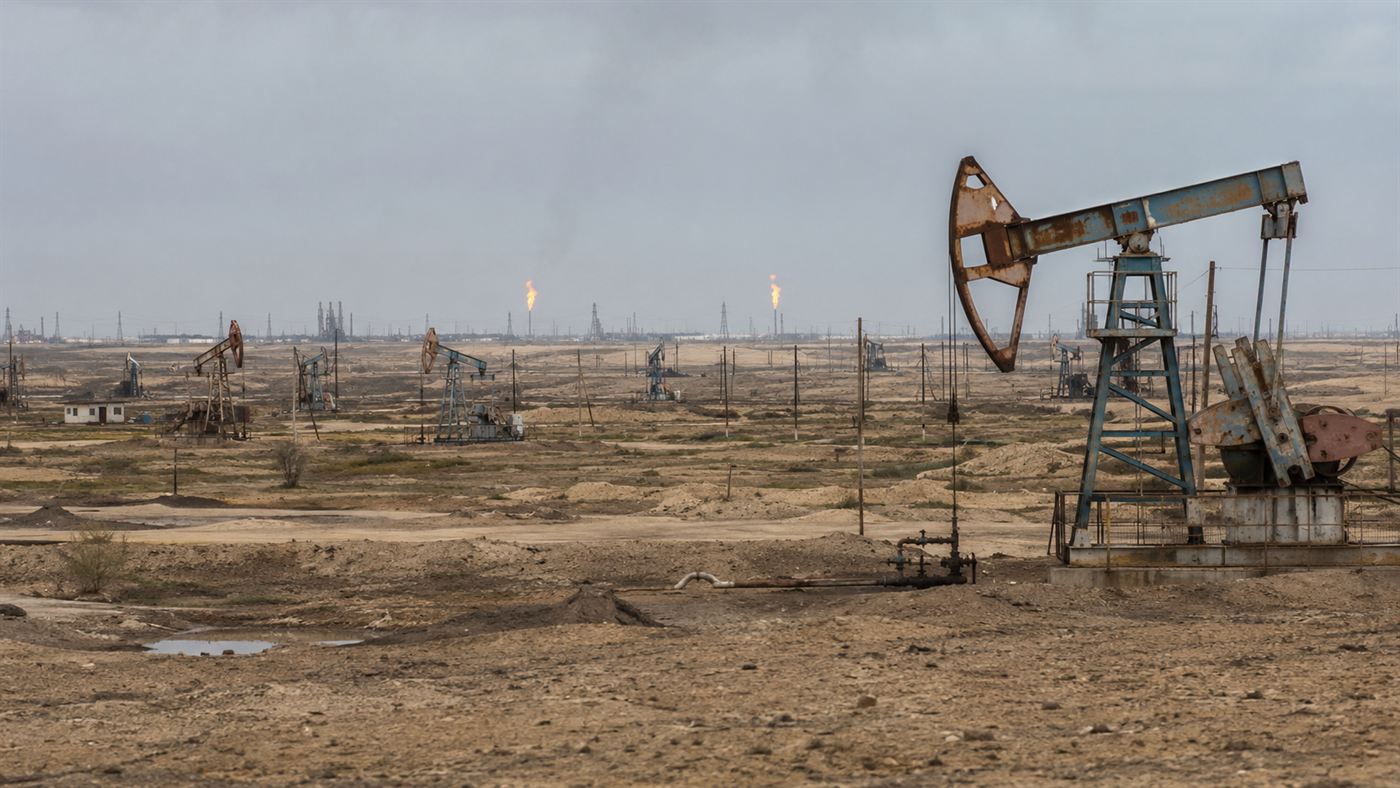The dry oil-and-gas landscape of the Absheron Peninsula near Baku with distant flames and pumping equipment
