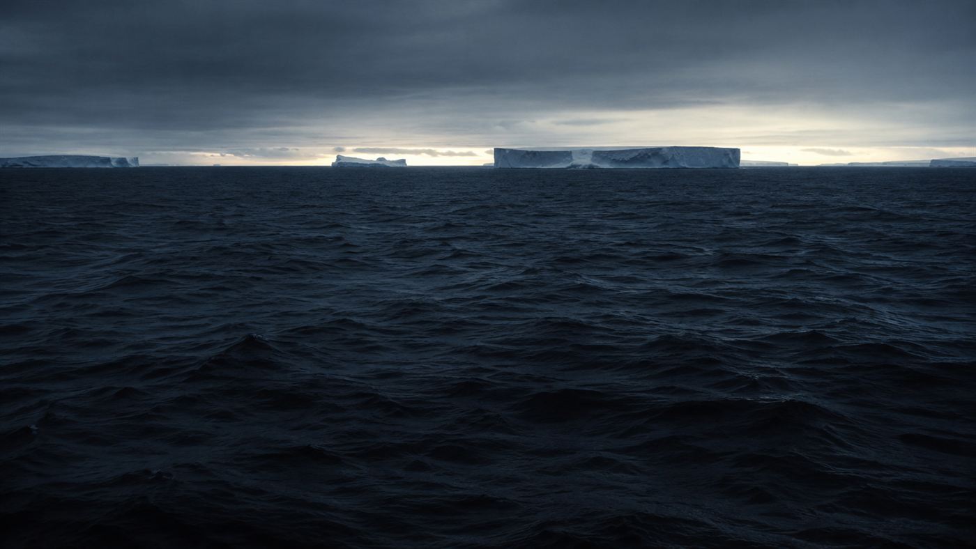 The dark surface of a cold southern ocean at dusk with distant icebergs, evoking the mystery of the Bloop