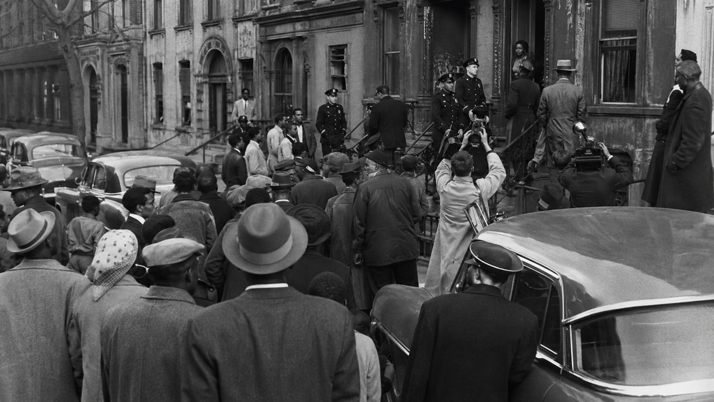 A 1947 crowd of onlookers and police gathered outside the Collyer brothers' Harlem brownstone