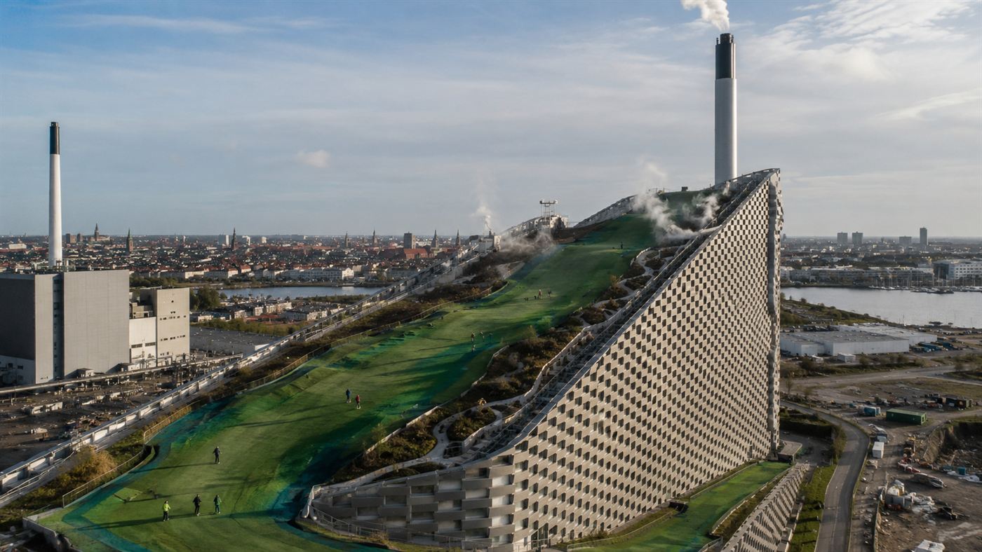 Skiers on the green rooftop ski slope of CopenHill, the Copenhagen waste-to-energy plant