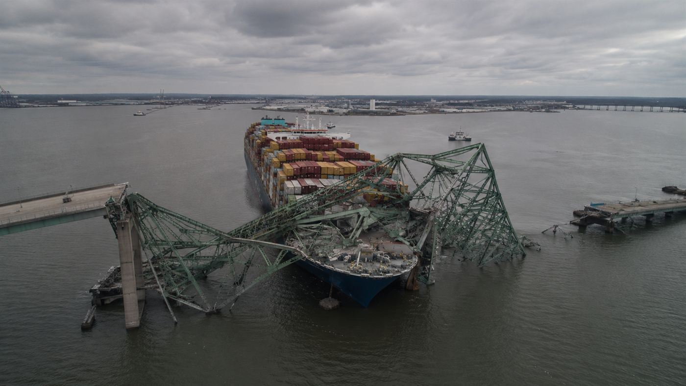 Aerial view of the Dali cargo ship stopped against the collapsed steel spans of the Baltimore bridge lying across the river