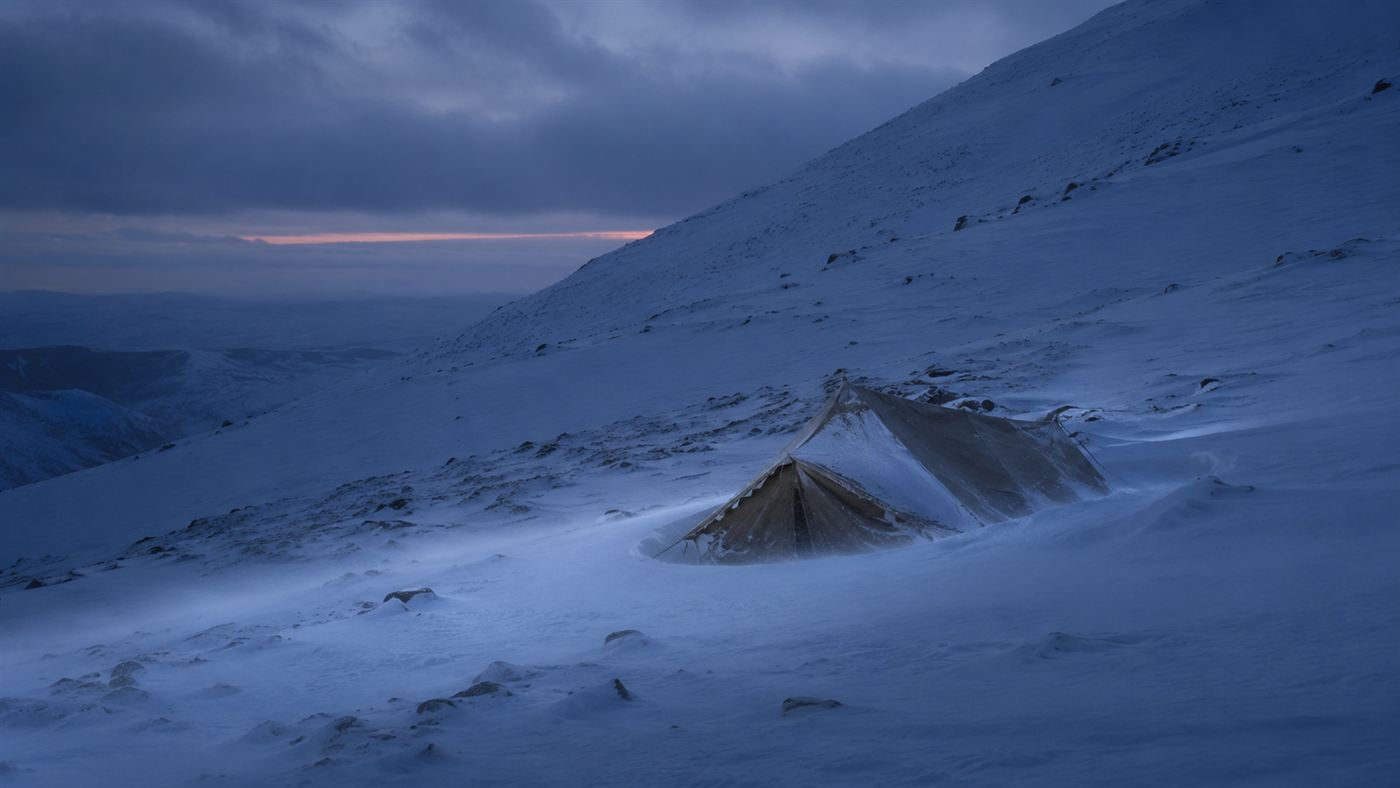 A snow-covered Ural slope at dusk with a half-buried tent, evoking the Dyatlov Pass incident of 1959
